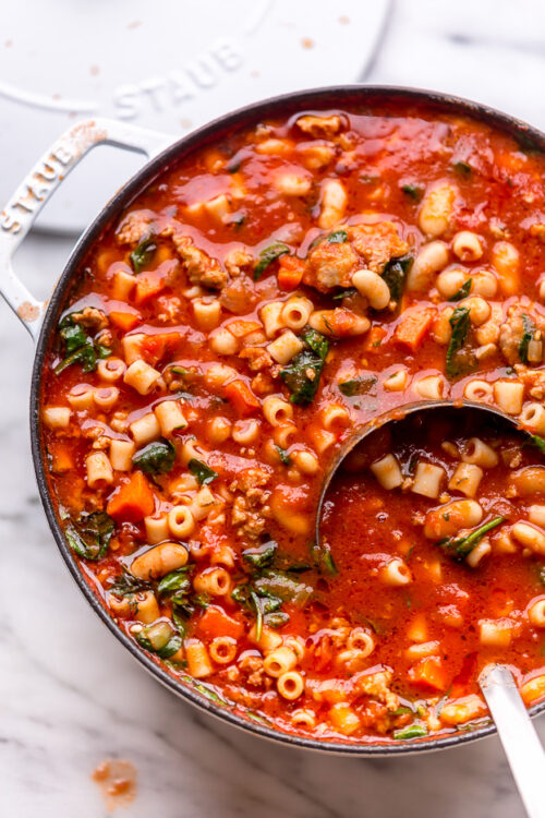 Large pot of pasta fagioli soup with ladle.